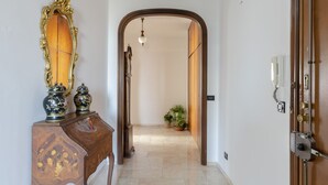 A hallway with a wooden door, a mirror, and a small table with decorative items. - JOIVY Front Sea Apt With Big Terrace In Chiavari (Chiavari)