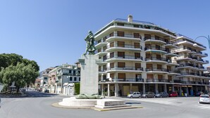 A multi-story building with balconies, a statue, and a roundabout. - JOIVY Front Sea Apt With Big Terrace In Chiavari (Chiavari)