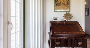 A room with a wooden piano, a framed picture on the wall, and a sunburst decoration on a dresser. - JOIVY Superb Villa For 7 W/Backyard And Bbq Area In Vaccarezza (Bobbio)