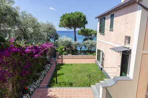 A courtyard with a view of the sea, surrounded by a building with green shutters and a tree. - JOIVY Villa W/Superb View And Private Garden In Mulinetti (Recco)