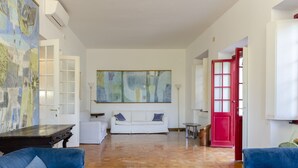 A spacious living room with a wooden parquet floor, a white sofa, and blue armchairs. - JOIVY Apt W/Amazing Sea View And Patio, Next To Port Of Rapallo (Rapallo)
