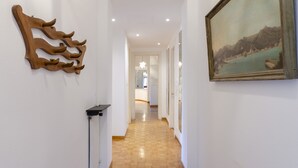 A hallway with a wooden wall art piece and a framed landscape painting. - JOIVY Apt W/Amazing Sea View And Patio, Next To Port Of Rapallo (Rapallo)