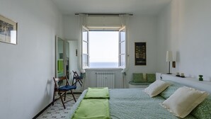 Une chambre à coucher avec un lit, une fenêtre, une chaise et un radiateur.