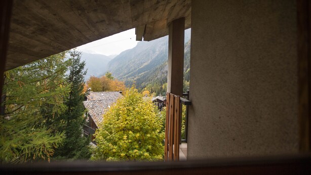 Blick vom Balkon mit Bergelandschaft im Hintergrund.