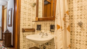 Ein Badezimmer mit Holzschrank, Waschbecken und Duschvorhang.