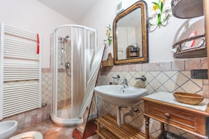 Un baño con ducha, lavabo y espejo.