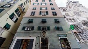 A building with a pharmacy sign, multiple windows with shutters, and a classical architectural style. - JOIVY Exclusive 3-bedroom flat near Cathedral of Genoa (Genoa)