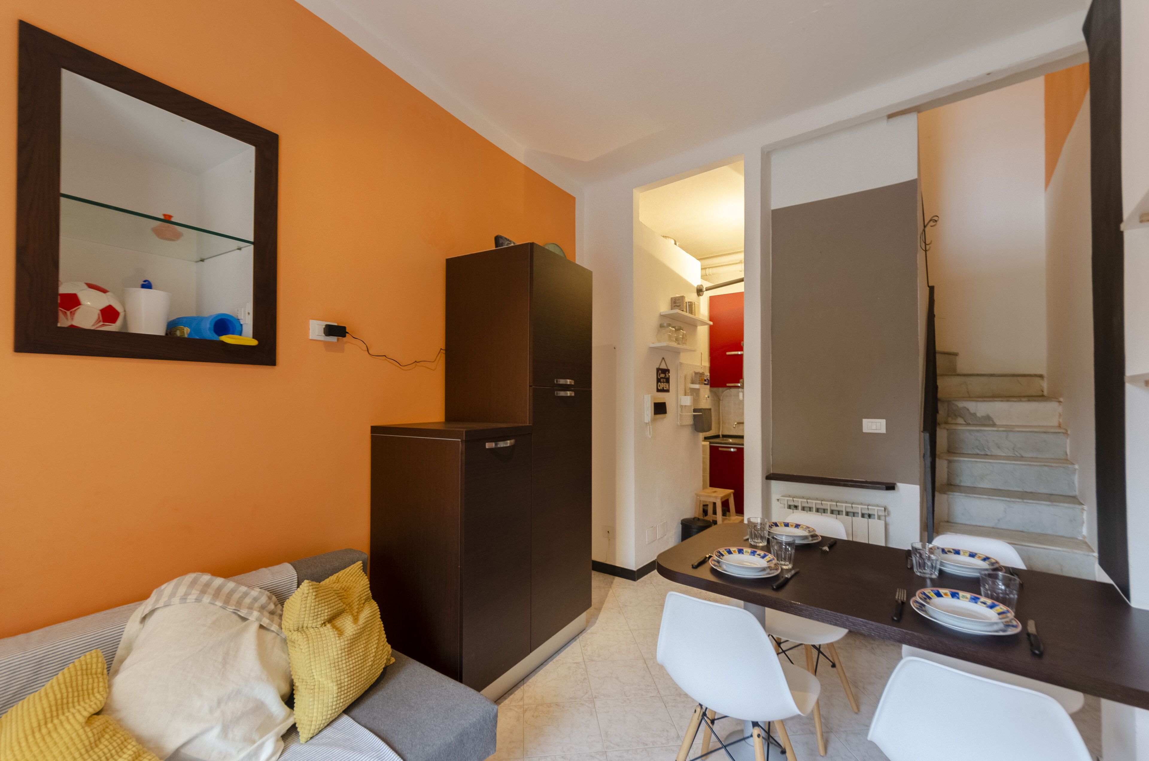 Una cocina compacta con refrigerador, una mesa de comedor para dos personas y una pequeña encimera.