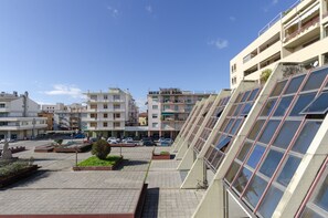 A residential area with multi-story buildings, a parking lot, and a small garden area. - JOIVY Spacious Apt For 6, Near Train Station And Beach (Sestri Levante)
