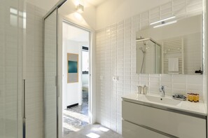 A modern bathroom with a glass shower enclosure, a large mirror, and a white vanity. - JOIVY Spacious Apt For 6, Near Train Station And Beach (Sestri Levante)