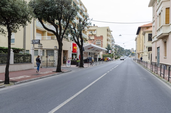 A street with buildings, a pedestrian, and a sign for a hotel.