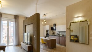 A modern apartment with a kitchen, dining area, and living room. It features a large island, a flat-screen TV, and a dining table with chairs. - JOIVY Chic Chiavari Apt With 2 Spacious Terraces (Chiavari)