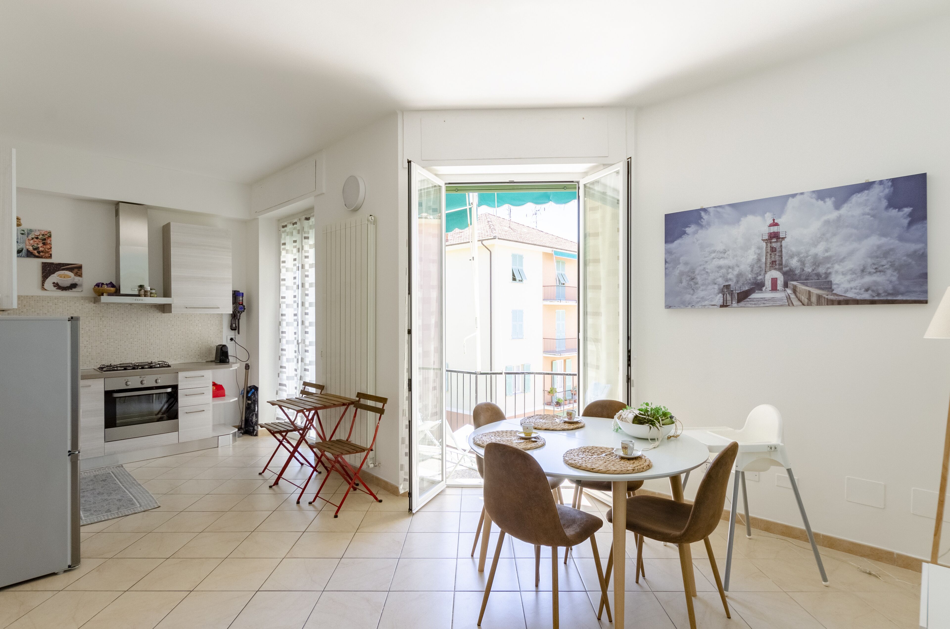 Una cucina moderna con zona pranzo, vista all'esterno e un quadro appeso al muro.