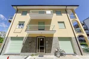 A multi-story building with a balcony, a bicycle parked outside, and a stone facade. - JOIVY Apt For 4, Near Centre, Beach And Train Station (Sestri Levante)