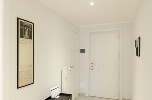 A hallway with a framed artwork, a radiator, and a door. - JOIVY Lovely Apt On The Historical Street Via Cantore (Genoa)