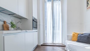 Eine moderne Küche mit weißen Schränken, einer Holz Arbeitsplatte und einem eingebauten Backofen.