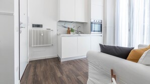 Eine moderne Küche mit weißen Schränken, einem eingebauten Backofen und einer Marmor-Spritzschutzwand.