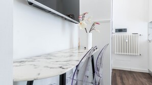 Eine moderne Küche mit Marmorarbeitsplatte, Backofen und weißem Heizkörper.