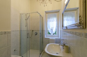 A bathroom with a glass-enclosed shower, a sink, and a window with a view. - JOIVY Lovely Apt For 4 On The Italian Riviera In Rapallo (Rapallo)