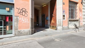An entrance to a building with a visible door and a window with a sign. - JOIVY Bright And Cozy Studio For 2 In Porta Genova (Milan)