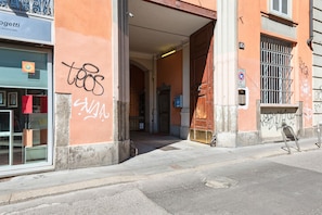 Experience the vibrant atmosphere of Poggetti, a building with a unique facade featuring graffiti and a metal gate.
