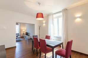 Ein Essbereich mit Tisch, Stühlen, einer Stehlampe und Blick ins Freie.