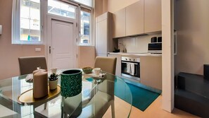 Una cocina moderna con una mesa de comedor de vidrio, un microondas y un horno empotrado.