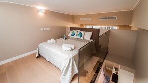 A modern bedroom with a bed, a bedside table, and a built-in TV.