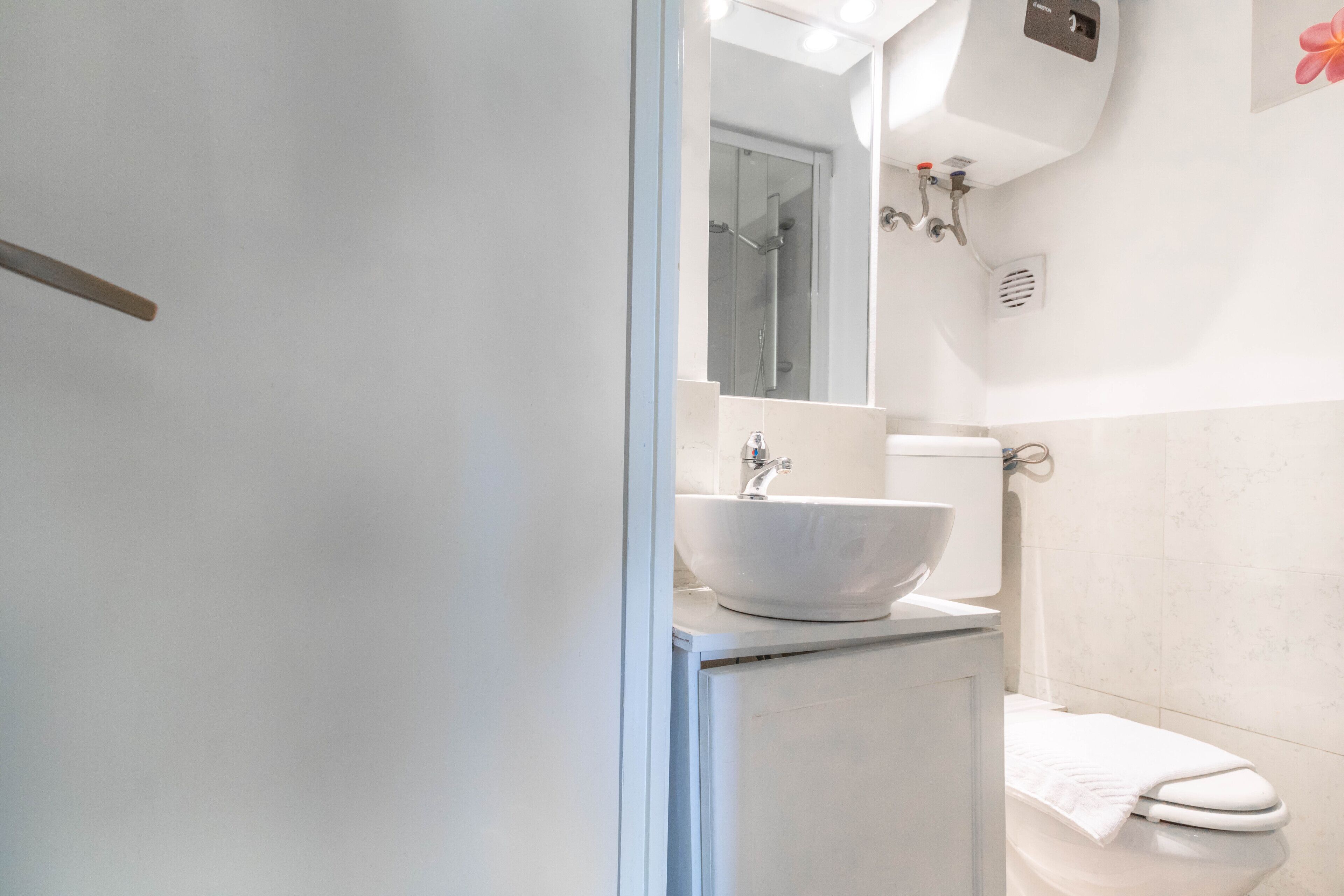 Ein Badezimmer mit Waschbecken, Spiegel und Toilette.