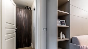 Une chambre à coucher comprenant un lit, une armoire et une étagère avec des objets décoratifs.
