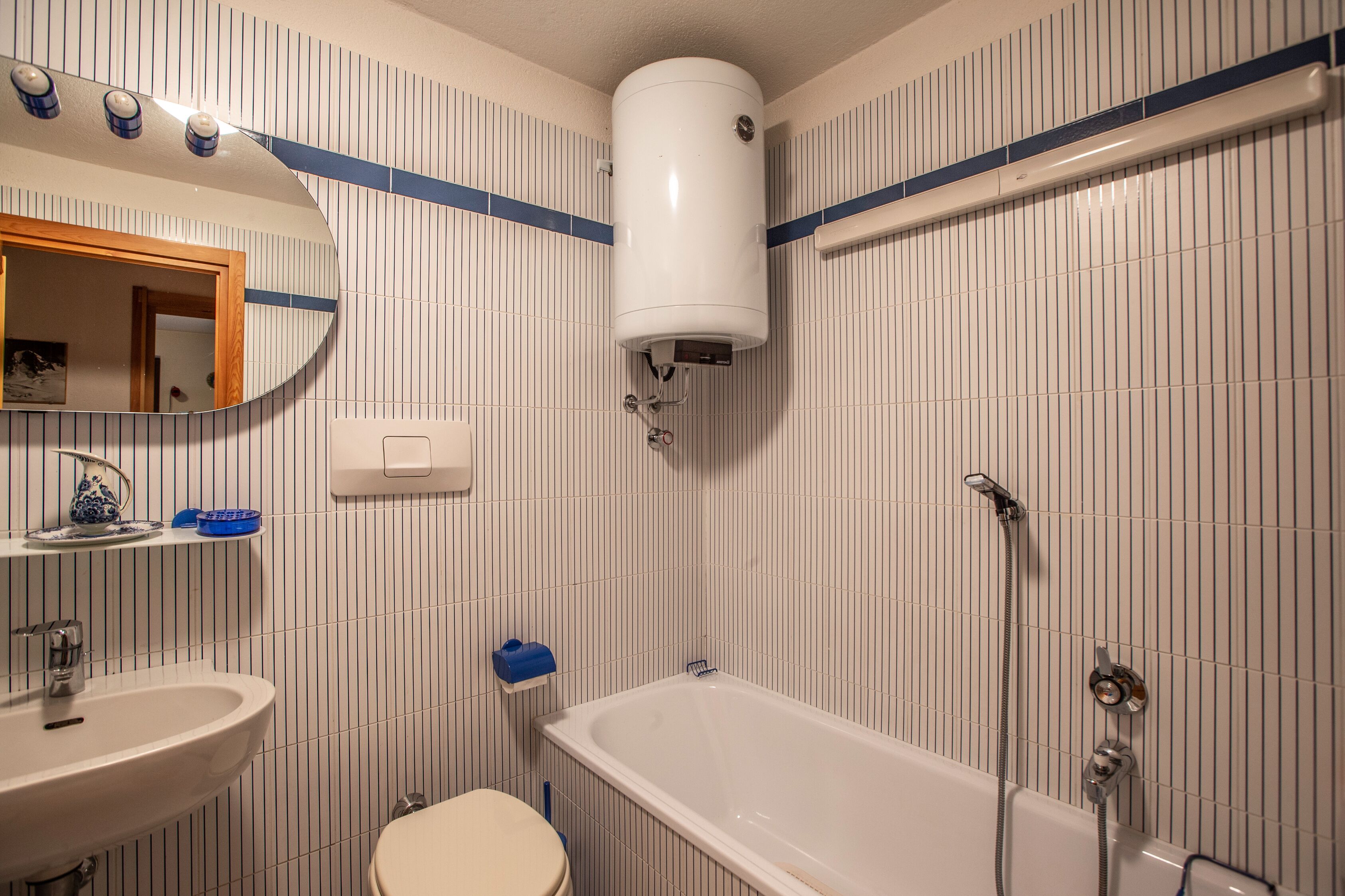 A bathroom with a sink, toilet, bathtub, and a mirror.