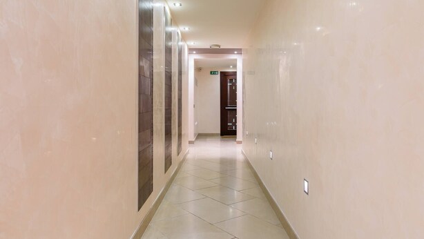 A long, narrow hallway with tiled floors and walls, leading to a door at the end. - JOIVY Bright Studio For 2 Close To Milano Centrale (Milan)