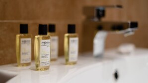 Four bottles of shampoo on a bathroom sink. - JOIVY Bright Studio For 2 Close To Milano Centrale (Milan)