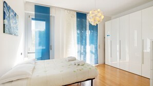 A bedroom with a bed, a wardrobe, and a window with curtains. - JOIVY Lovely Flat For 4 W/Balcony Near Porta Romana (Milan)