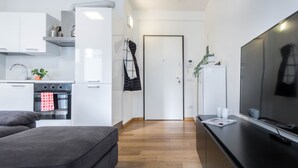 A modern kitchen with white cabinets, a built-in oven, and a black countertop.