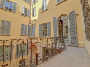 A building with multiple windows, some with shutters, and a balcony with ornate metal railings. - JOIVY Fulcorina Sforza Splendid flat in Central Milan (Milan)
