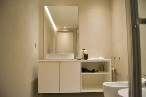 A modern bathroom with a large mirror, a sink, and a toilet. - JOIVY Fulcorina Sforza Splendid flat in Central Milan (Milan)