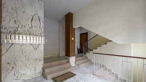 A marble-floored lobby with a staircase, a wooden column, and a metal railing. - JOIVY Family Flat W/Terrace & Parking Near Beach (Sestri Levante)