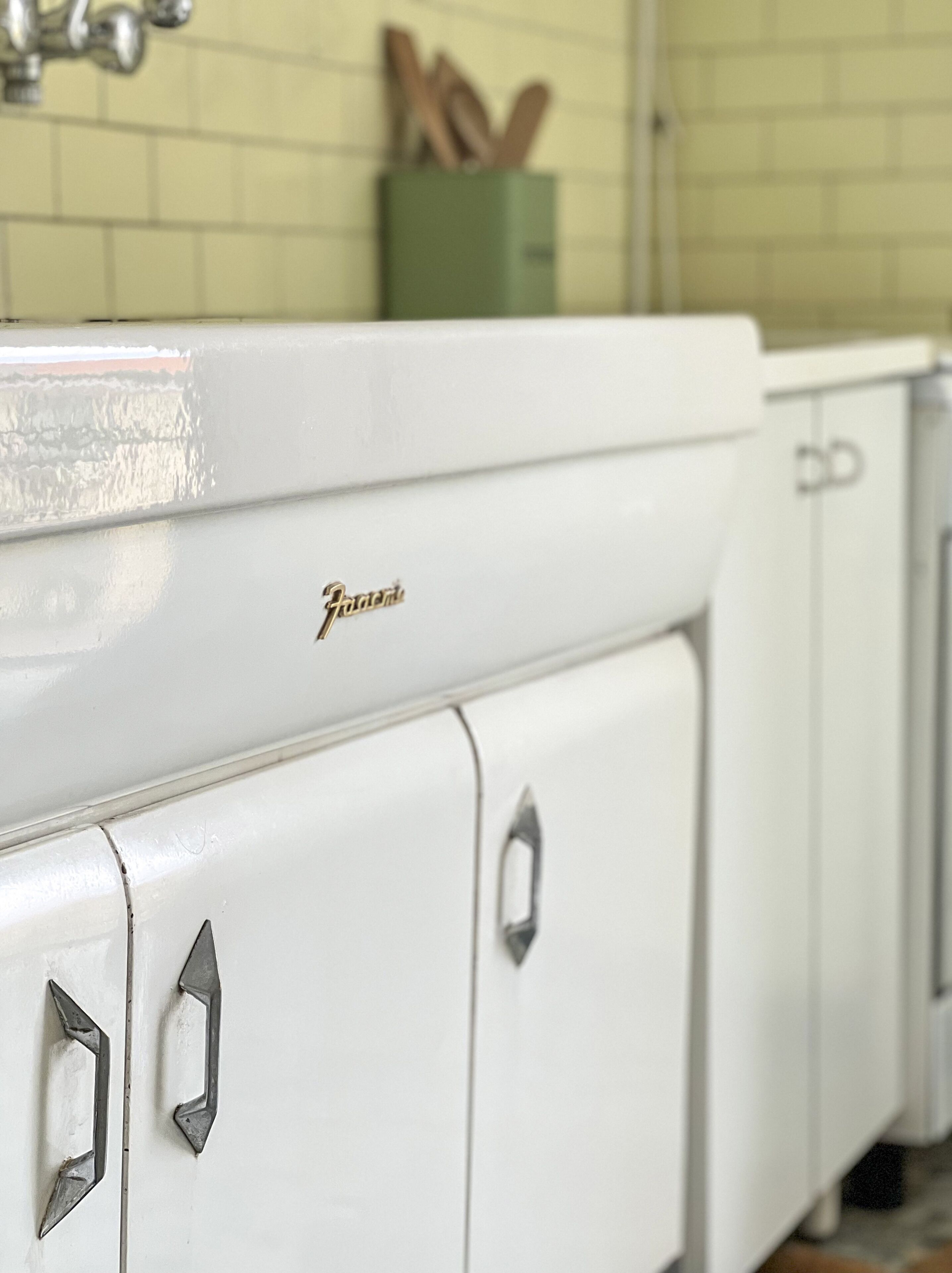 Una cocina con armarios blancos y una campana extractora de acero inoxidable.