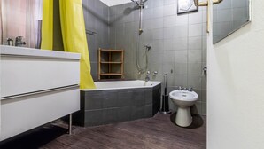 A modern bathroom with a bathtub, a sink, and a shower.