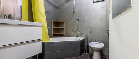 A modern bathroom with a bathtub, a sink, and a shower.
