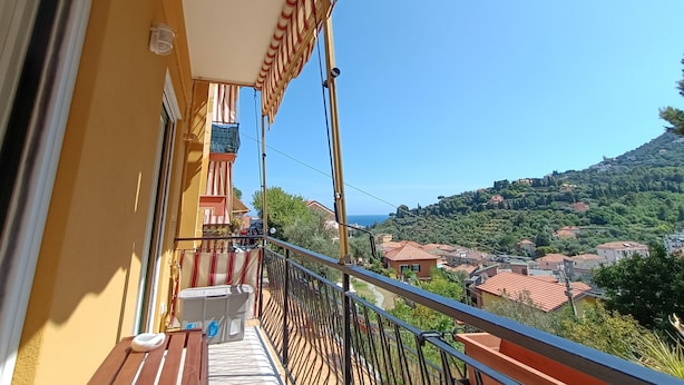 A balcony with a view of a hillside town and the sea. - JOIVY Bright Flat W/2 Balconies & Sea View (Alassio)
