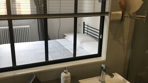 A bathroom with a window, a sink, and a mirror. - JOIVY Stylish Apt in Centre of Cernobbio (Cernobbio)