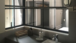 A bathroom with a large window, a sink, and a mirror. - JOIVY Stylish Apt in Centre of Cernobbio (Cernobbio)