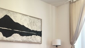 A red sofa, a lamp, and a painting on the wall. - JOIVY Stylish Apt in Centre of Cernobbio (Cernobbio)