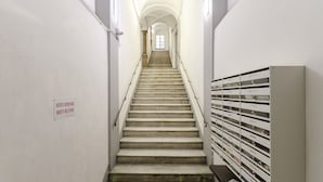 A staircase leading to a landing with a row of mailboxes on the right. - JOIVY Cute Flat Near The Aquarium (Genoa)
