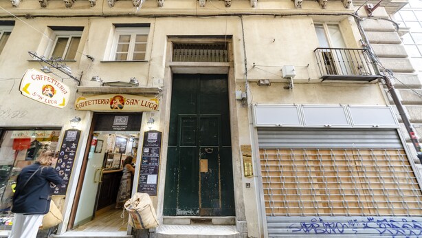 A building with a cafe named "Caffetteria San Luca" and a closed metal shutter door. - JOIVY Cute Flat Near The Aquarium (Genoa)