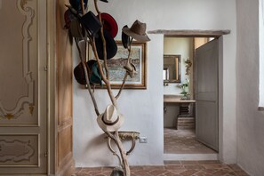 Un pasillo con un perchero que sostiene sombreros y un cuadro en la pared.