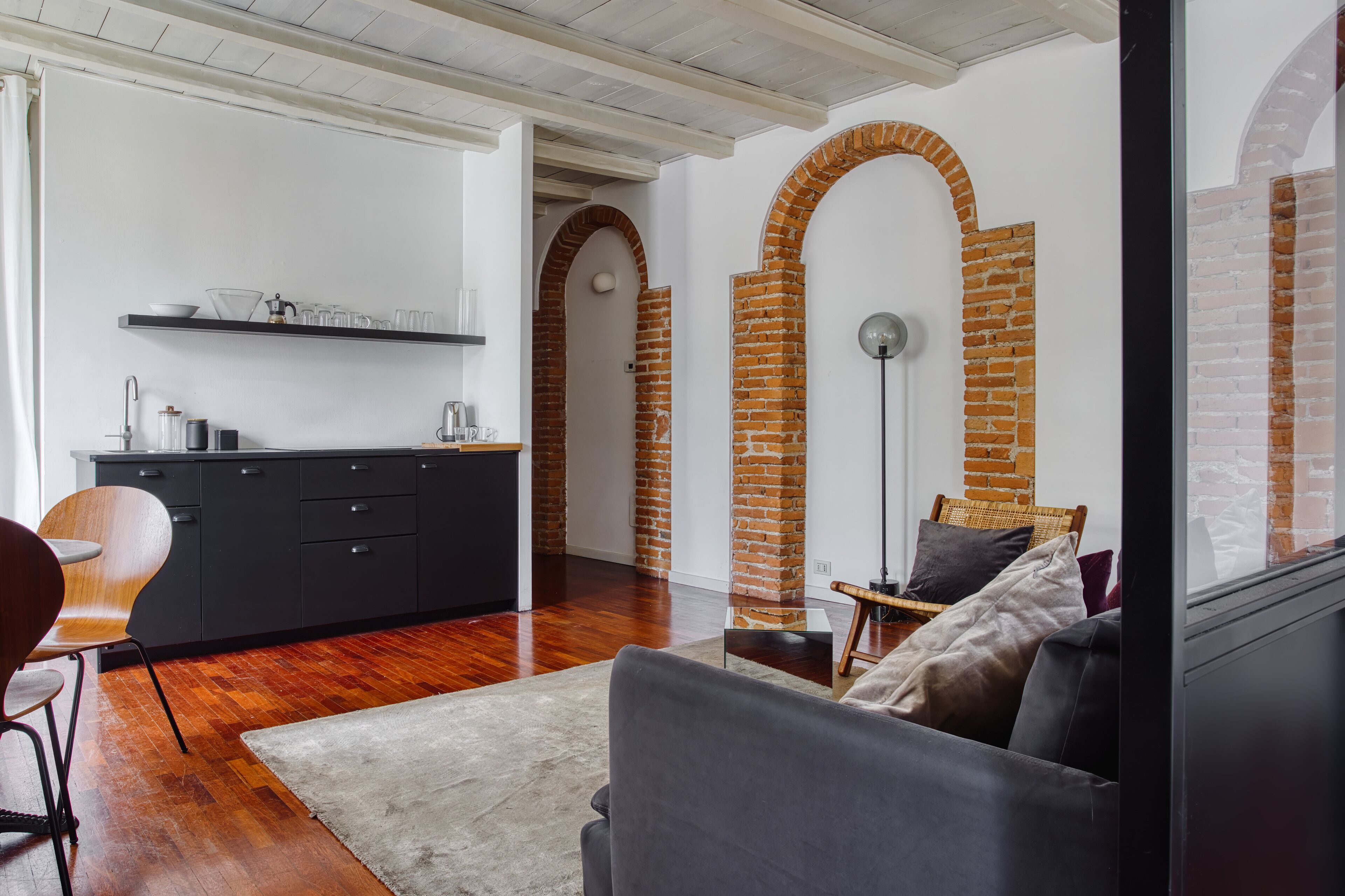 Un espacio habitable moderno con cocina, sofá y zona de comedor.