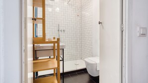 A modern bathroom with white tiled walls, a wooden vanity, a toilet, and a shower area. - JOIVY Superb Studio In The Centre Of Milan (Milan)